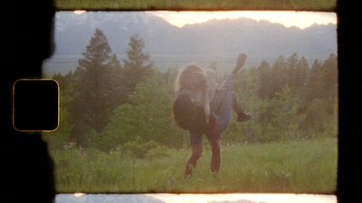 couples dip kiss on super 8 film overlooking the grand tetons at sunset