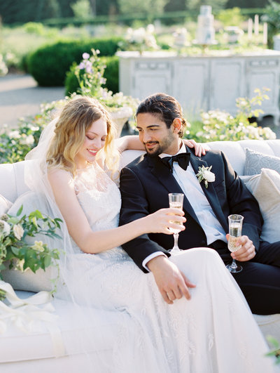 classy bride and groom moment cheersing with champagne at their outdoor wedding