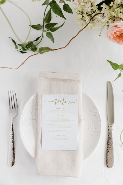 a-linen-napkin-topped-with-a-gold-lettered-menu