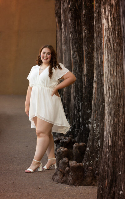 senior-girl-posing-in-white-dress-at-fort-worth-water-gardens