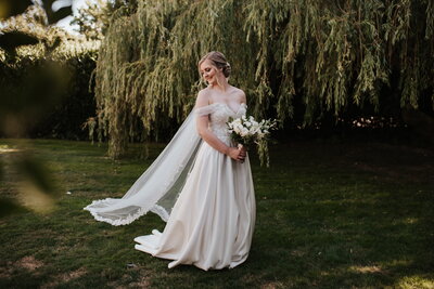 Bride standing by willow tree