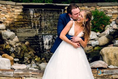 Bride and Groom embracing in front of a waterfall