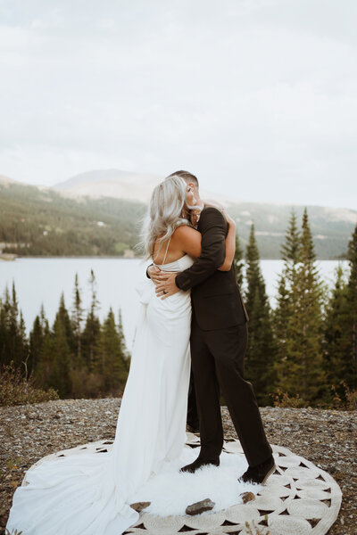 couple hugging at their Colorado elopement in front of the mountains. They eloped in Breckenridge colorado on the top of a mountain where they said their vows and celebrated with family and friends. Plan your Breckenridge elopement with me and we will find the best and most secluded mountain elopement locations in Colorado!