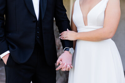 Detail of bride holding groom's arm