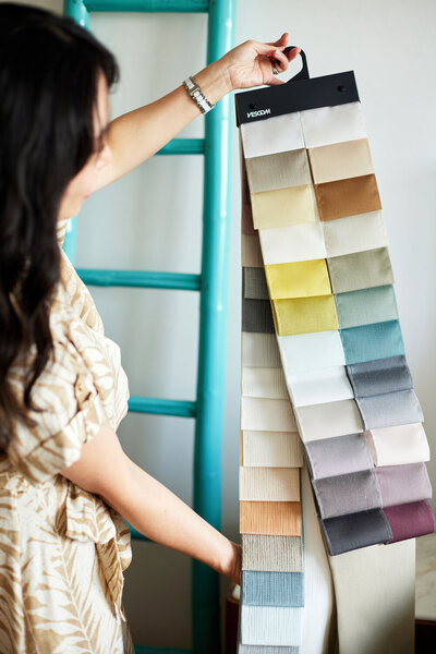 Christen, an interior designer, holding cloth patches in front of her