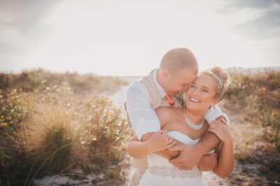 Golden hour wedding photo of man hugging woman from behind