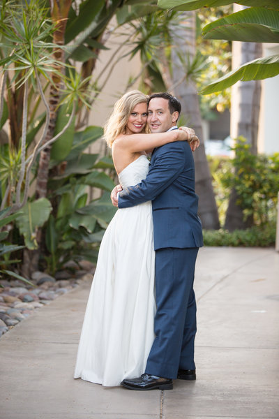 Bride and Groom hugging at their wedding venue at The Dana in San Diego