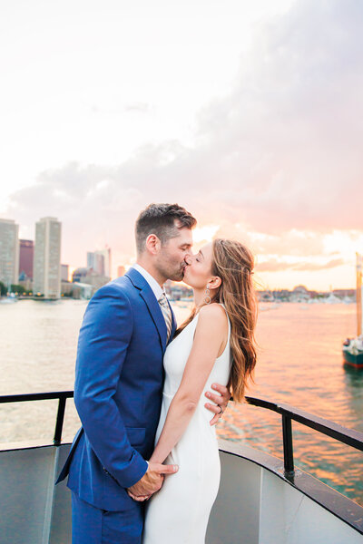 Bride and groom kissing with Boston Harbor in the background