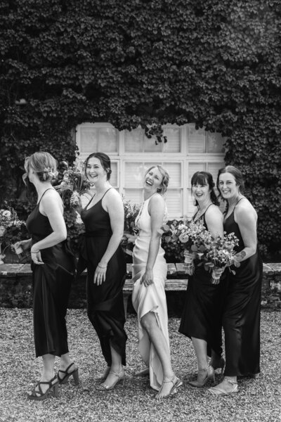 bridesmaids and brides pose during funny candid photo