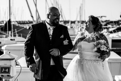 Bride and groom laughing together as they walk the Erie Yacht Club