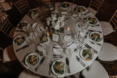 Photo of the table set-up with food on plates and flower centerpiece in the middle