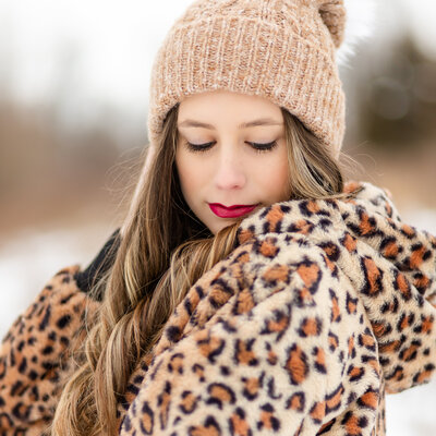 Senior girl in the snow with leopard print jacket