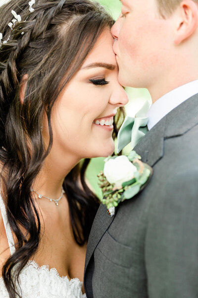 Close up of couple on wedding day, forehead kisses