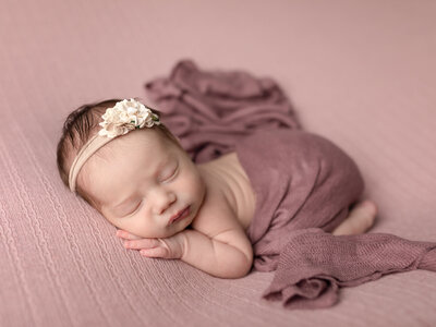 newborn baby posed with pink for studio portraits