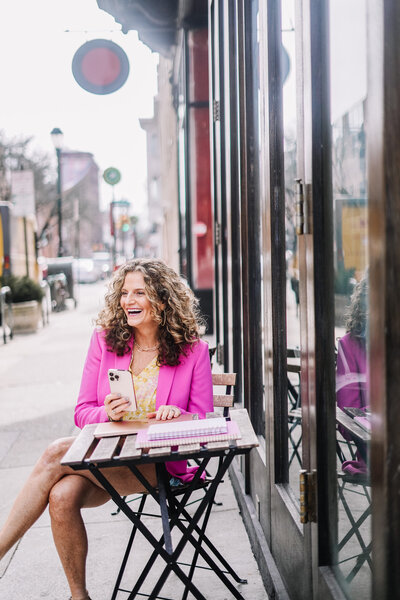 woman sitting with pink jacket outside