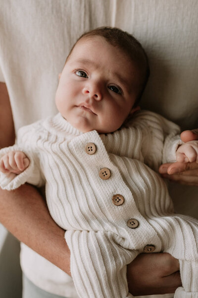 Pasgeboren baby kijkt in de camera tijdens newbornshoot