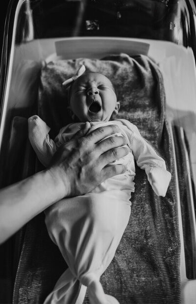 Black and white newborn photo in hospital bassinet