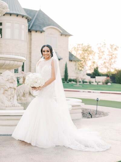 Portrait of bride in a trumpet gown with tulle and wedding bouquet