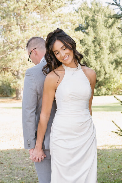 couple meeting back to back holding hands before wedding ceremony