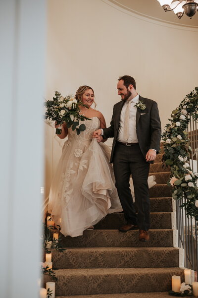 Bride and groom walking down staircase