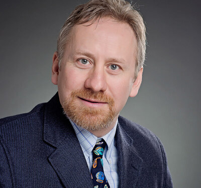 Male exective headshot with blue jacket and tie