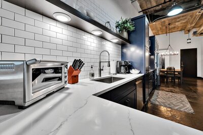 Kitchen with subway tile and stainless steel appliances in this three-bedroom, two-bathroom vacation rental condo in the historic Behrens building in downtown Waco, TX.