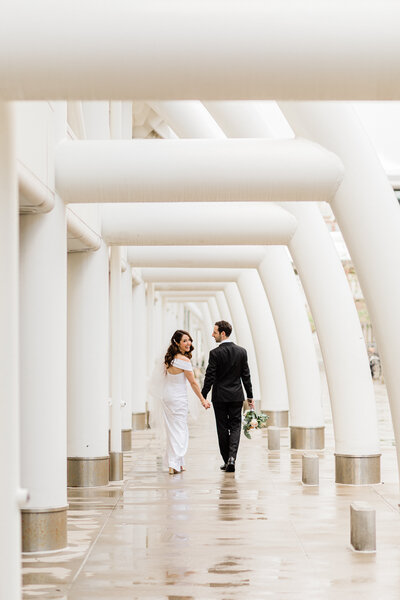 bride and groom walking and bride looking back during their first look at denver union station by colorado wedding photographer Diana Coulter