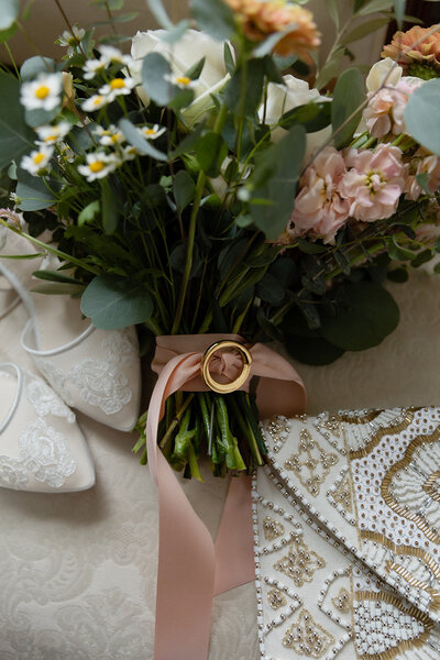 brides details of pink bouquet white shoes and gold clutch