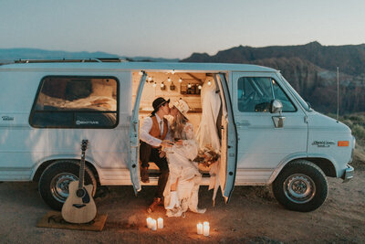 man and woman sitting in a van while kissing