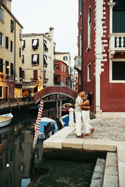 Couple hugging and smiling with canal backdrop Venice Italy