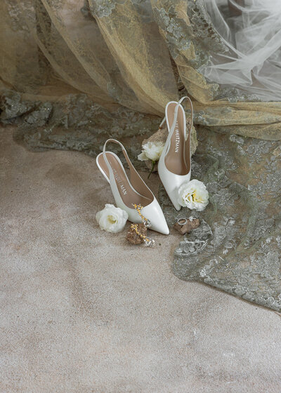 a pair of bride sandal with flowers on the beach floor