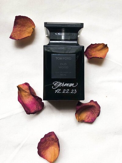 calligraphy engraved wine bottle next to dried roses