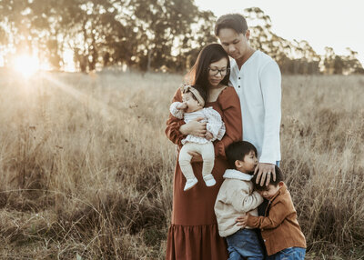 Sydney family of five in a grassy field at sunset.