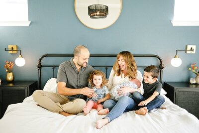The Tepper family laughing on a bed
