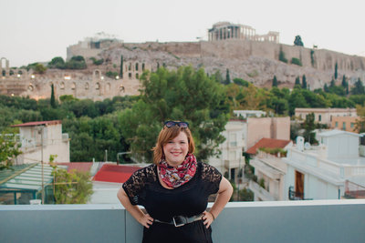 Kate Timbers stands in front of the Acropolis when traveling to Athens, Greece.