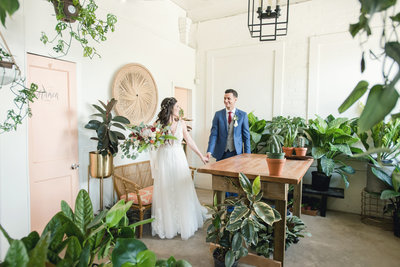 Bride leads groom through greenhouse-inspired wedding venue