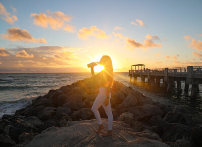 Woman posing against the sunrise on the beach
