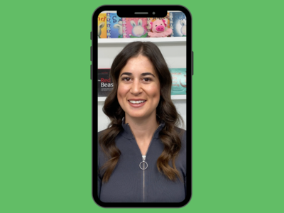 Happy adolescent girl stacking cups with psychologist