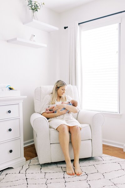 Mom holding newborn baby in rocker