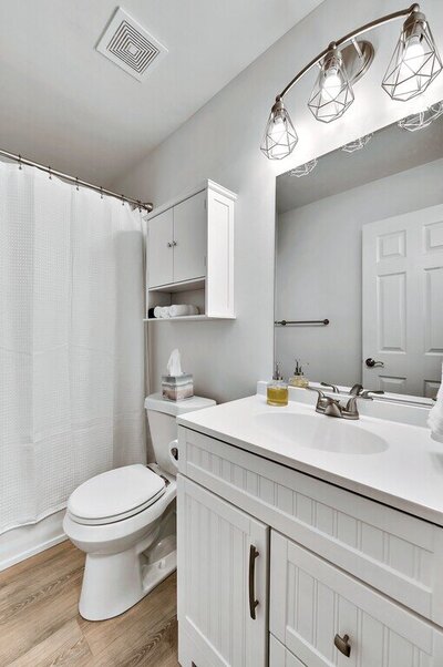 Bright white bathroom in this 2-bedroom, 1 bathroom vacation rental home located 4 minutes from delicious Magnolia Table and 5 minutes from the beautiful Baylor campus in Waco, TX