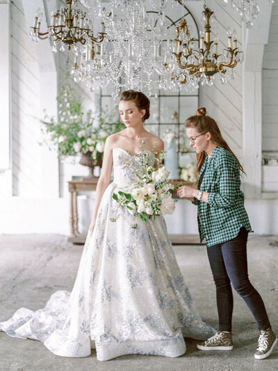 Meg adjusting a bouquet that a bride is holding