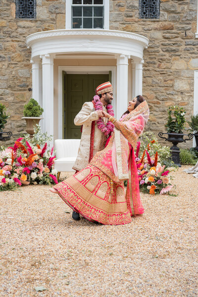 A couple stands near each other and press their foreheads together while dressed in wedding attire in Park Chateau Estate and Gardens in New Jersey.