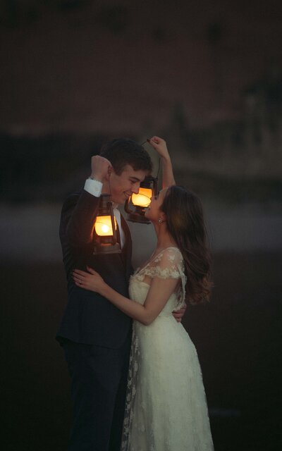 A romantic scene of a couple holding vintage lamps next to the historic Kilchurn Castle in Scotland, capturing a magical moment in a stunning setting