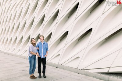 Bride to be holds her Groom's arm during a photo session outside The Broad in Los Angeles