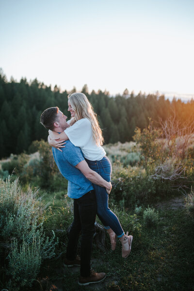 Sacramento Wedding Photographers capture man lifting woman during outdoor engagement session