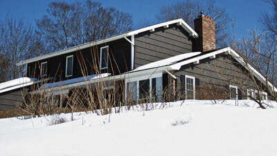 Branding photo of Author Linda Brooks home and lawn covered in snow