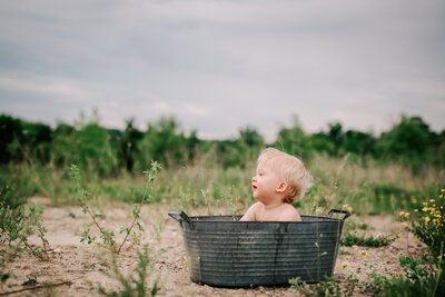 baby having a post cake smash bath outside