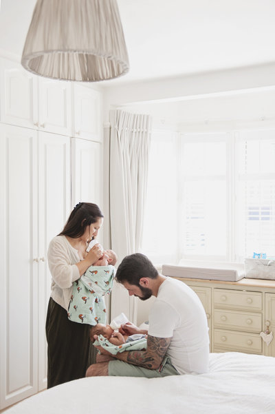 Parents feed their new baby boys during an at-home photo shoot