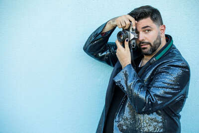 A photographer holding a camera up to their eye.