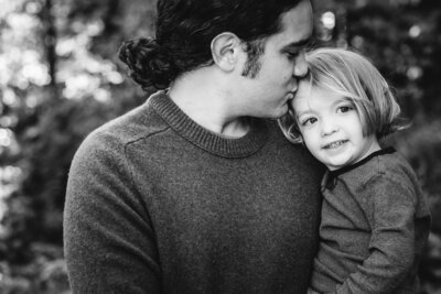 Dad gives his two year old son a kiss on the forehead by Vermont Family Photographer